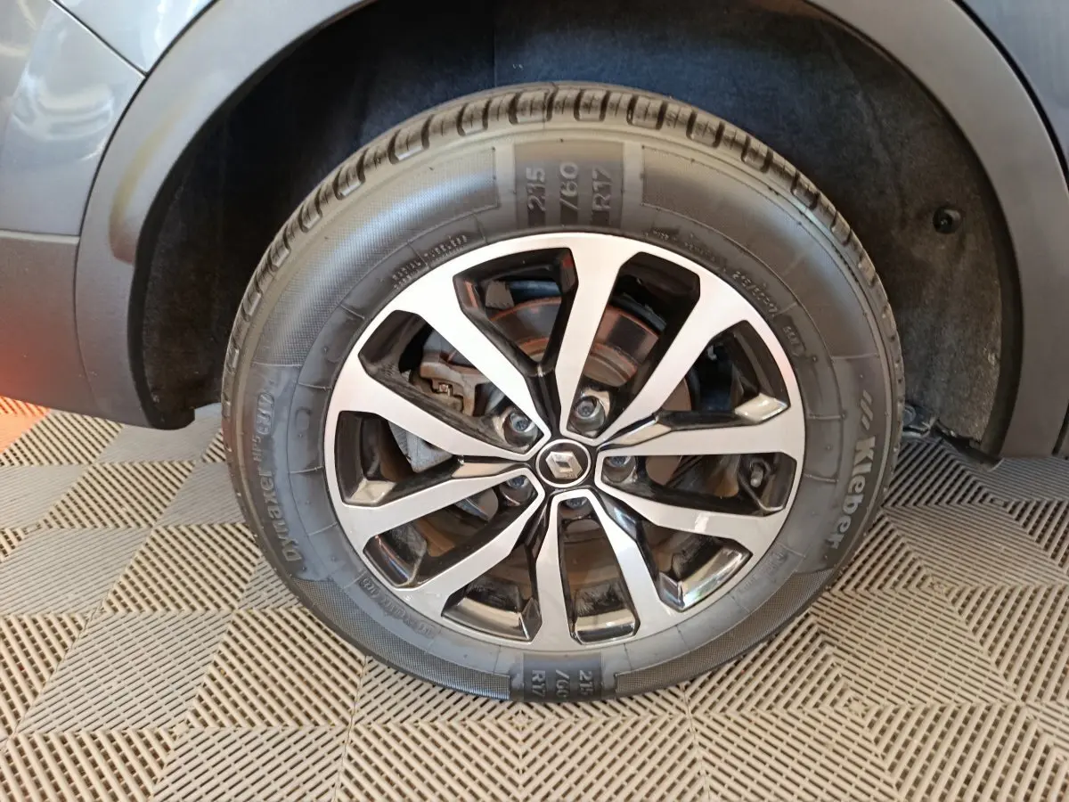 Gros plan sur la roue avant droite du Renault Kadjar gris foncé, mettant en valeur la jante alliage au design moderne.