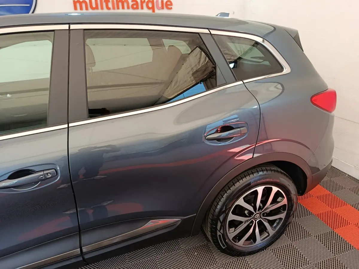 Vue latérale droite du Renault Kadjar Business gris foncé, mettant en valeur la roue arrière et les contours chromés.