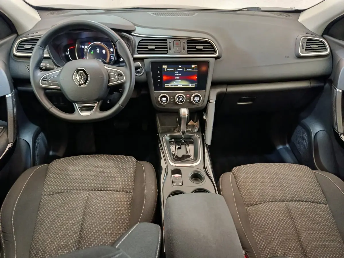 Vue intérieure avant du Renault Kadjar 2022 Business Blue dCi, tableau de bord avec écran tactile et volant multifonctions noir.