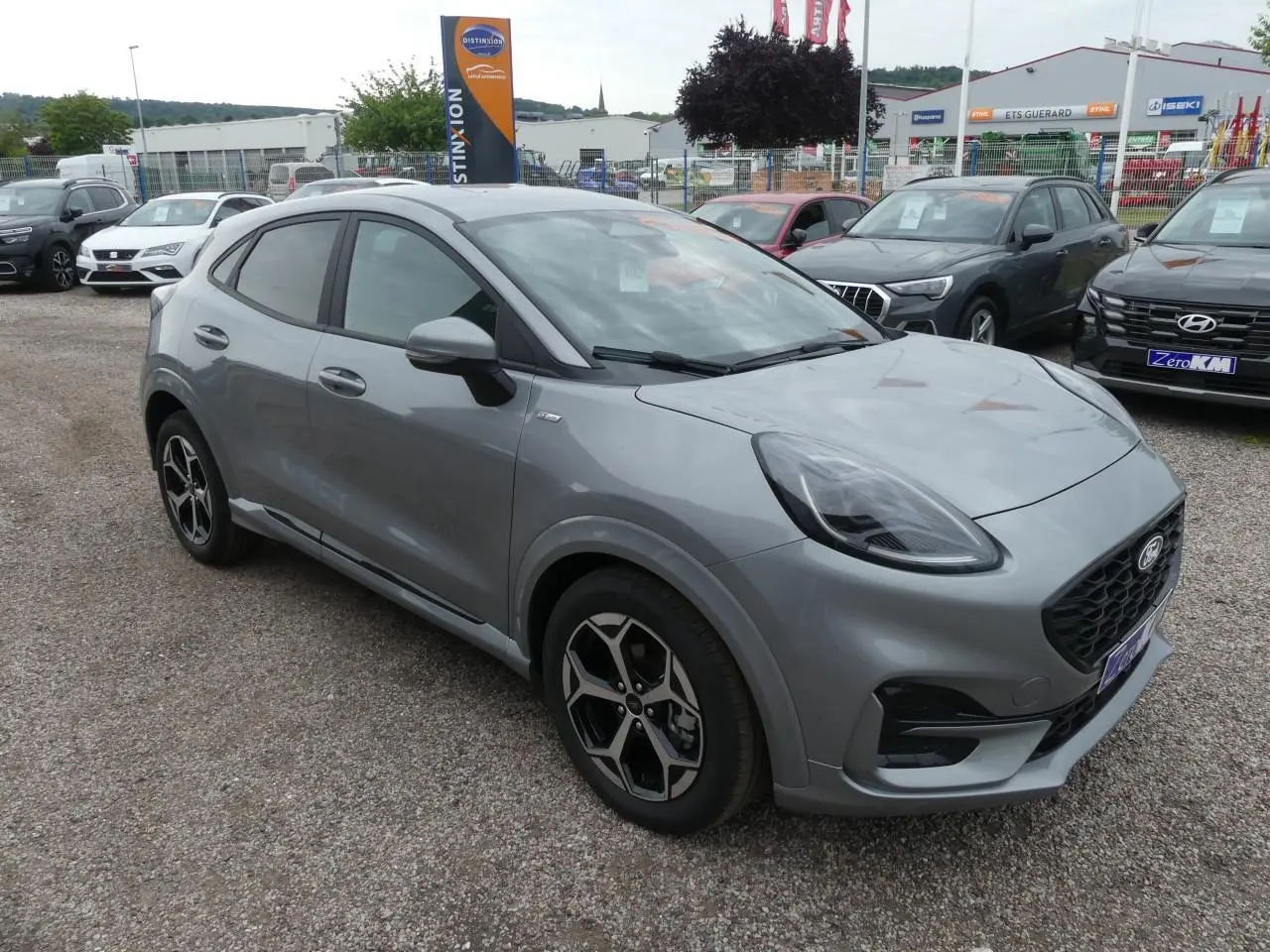 Ford Puma 2025 gris métallisé en vue 3/4 avant droit, avec jantes alliage et calandre noire sportive.