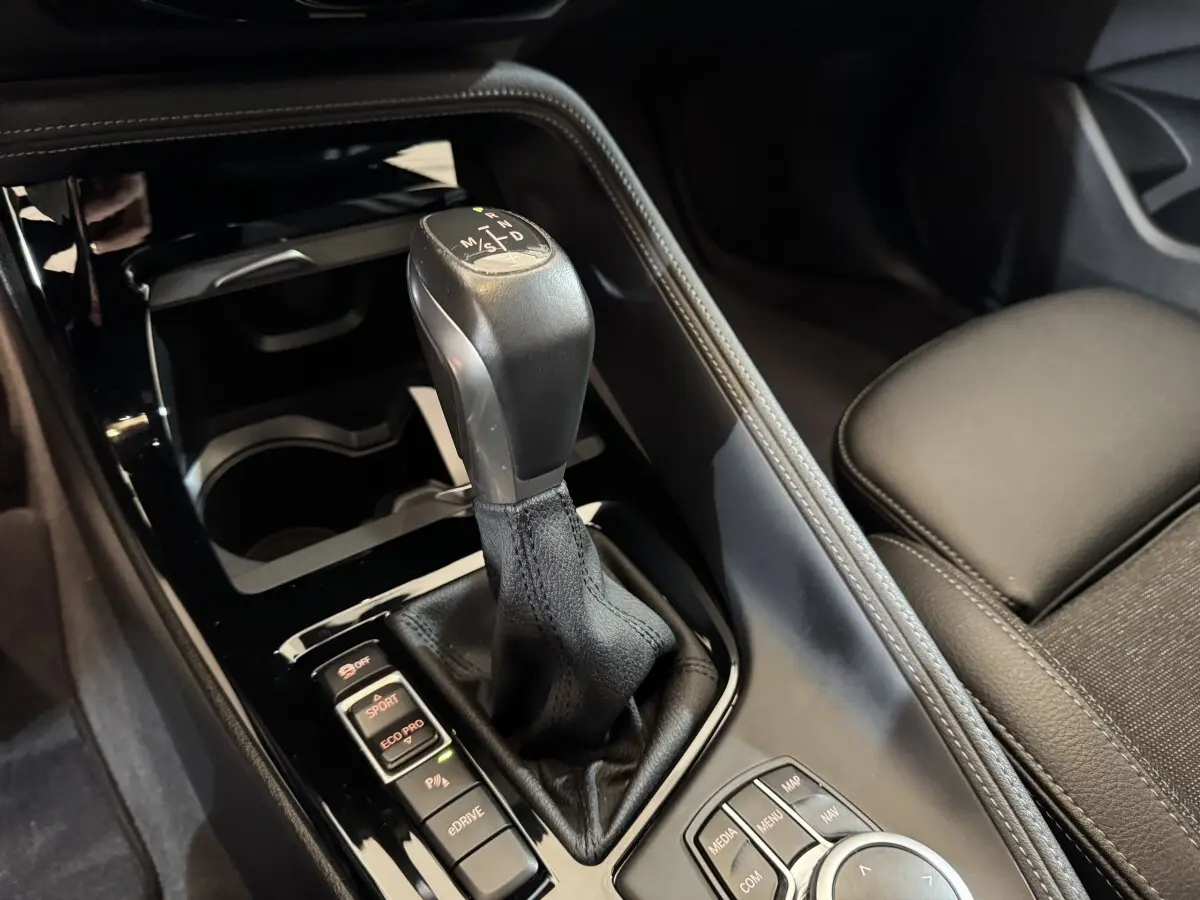 Gros plan sur la commande de boîte automatique et les modes de conduite du BMW X2 xDrive25e M Sport, intérieur noir.