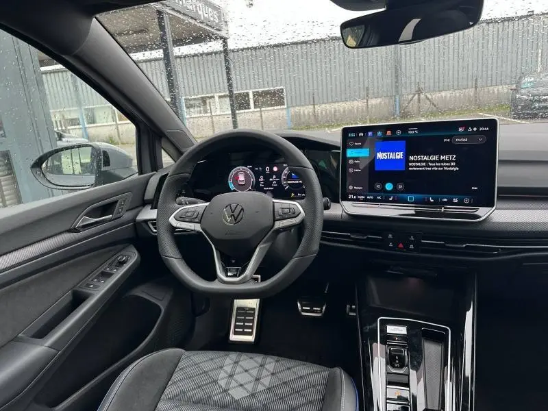 Vue intérieure avant de la Volkswagen Golf 2.0 TDI R-Line 2026, tableau de bord moderne gris avec écran tactile et volant cuir multifonction.