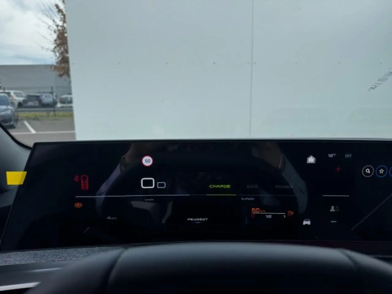 Tableau de bord numérique panoramique de Peugeot 5008 bleu Ingaro, vue depuis le siège conducteur.