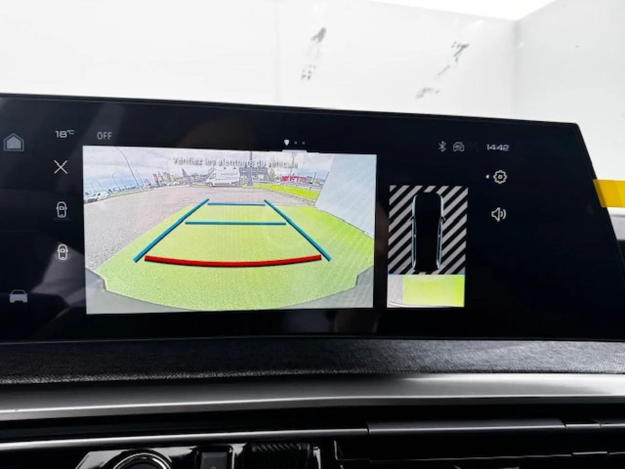 Écran tactile du tableau de bord montrant la caméra de recul et l’aide au stationnement du Peugeot 5008 bleu Ingaro.