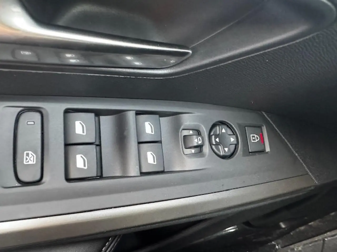 Gros plan sur les commandes des vitres et rétroviseurs côté gauche d’un Peugeot 5008 Bleu Ingaro 2025.