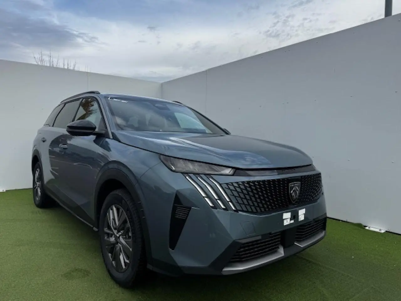 Peugeot 5008 bleu Ingaro métal vue 3/4 avant droit avec calandre noire et feux LED 3 griffes.