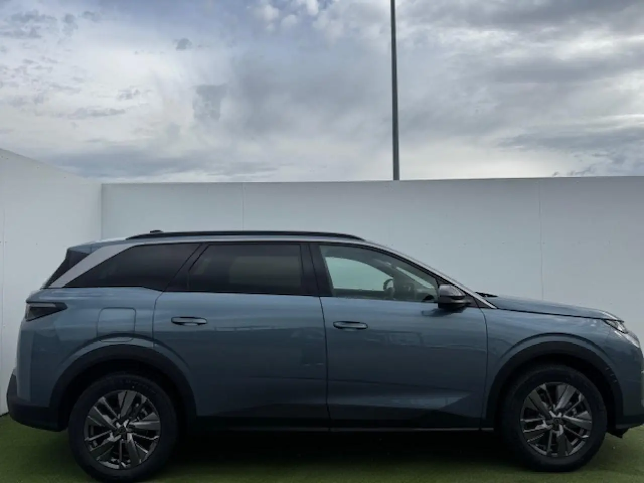 Peugeot 5008 bleu Ingaro métal vue de profil côté gauche, avec jantes alliage 18 pouces et toit noir panoramique.