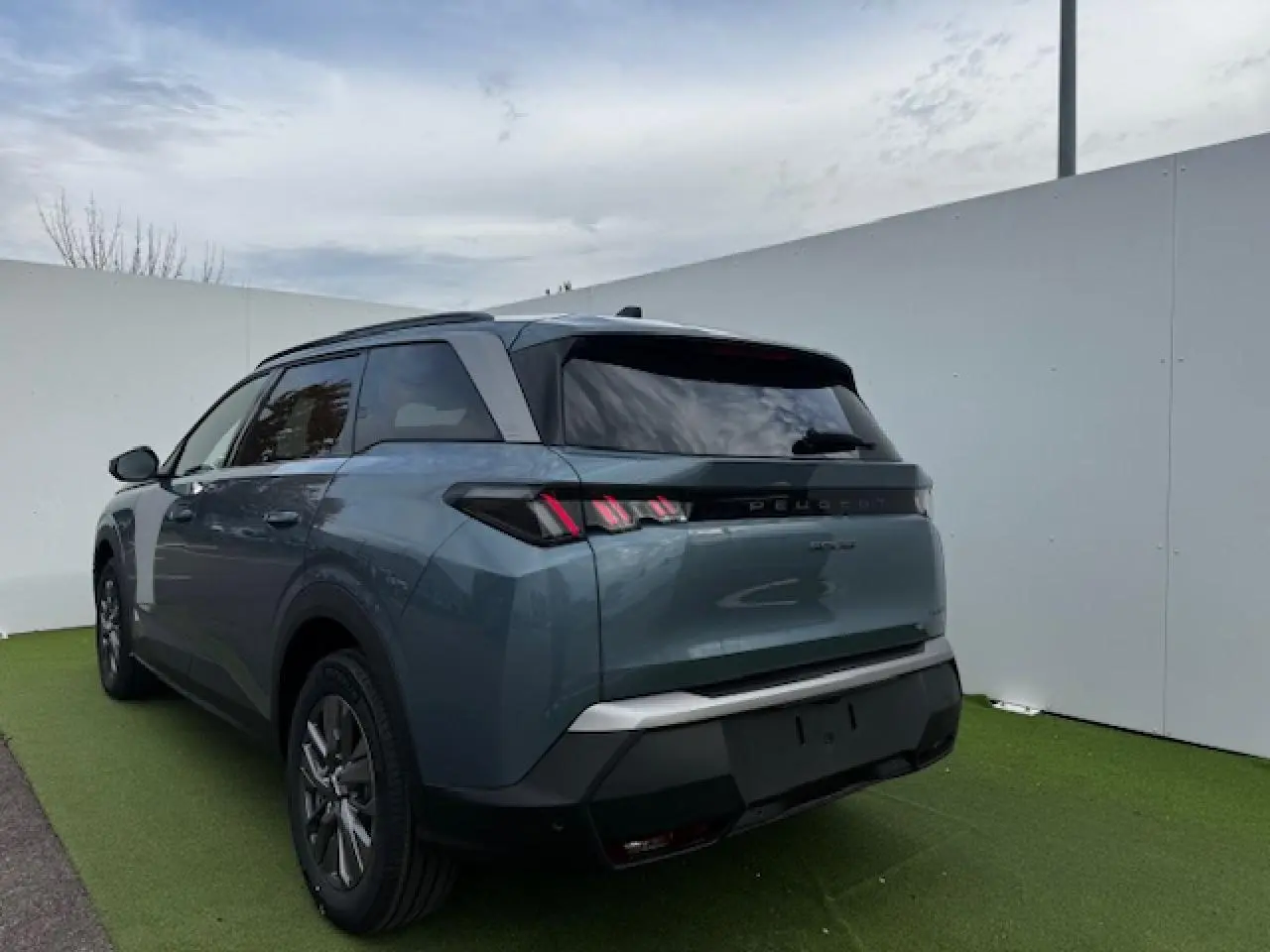 Vue 3/4 arrière droite du Peugeot 5008 bleu Ingaro métallisé avec feux arrière LED à griffes distinctives.