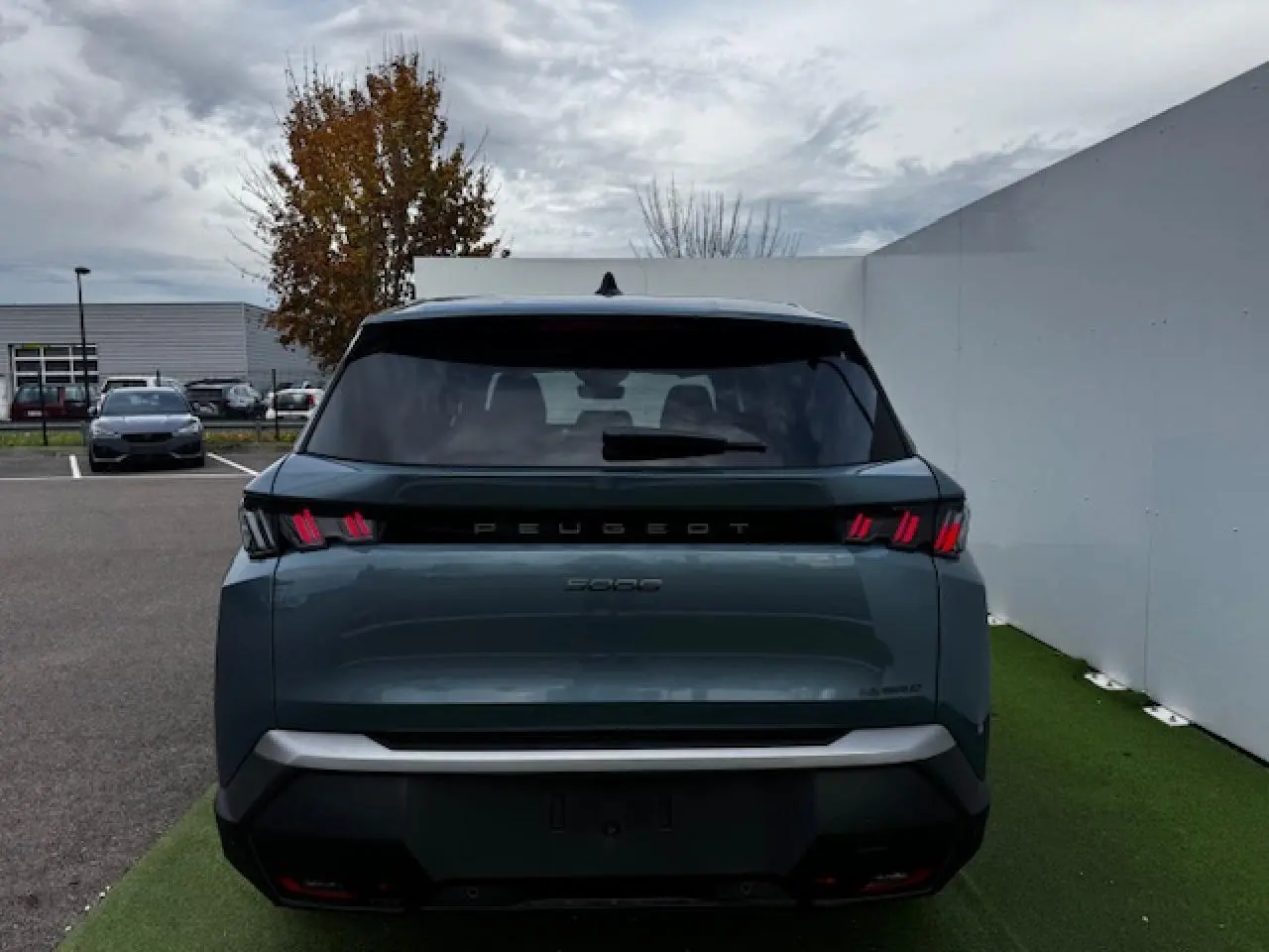 Vue arrière du Peugeot 5008 bleu Ingaro métallisé 2025 avec feux arrière à LED en forme de griffes distinctives.