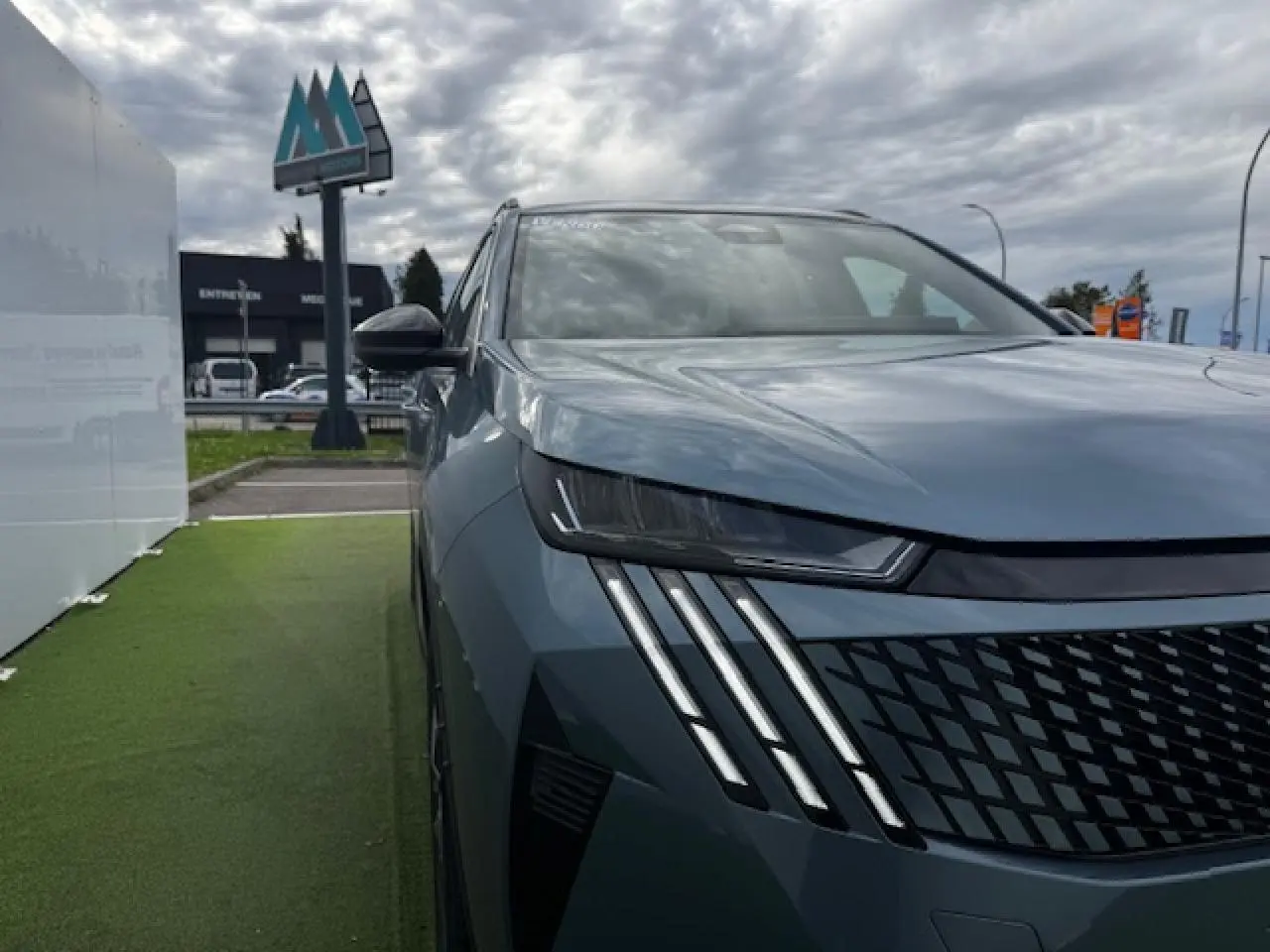 Vue 3/4 avant gauche du Peugeot 5008 bleu Ingaro avec ses phares LED à griffes distinctives et calandre noire.