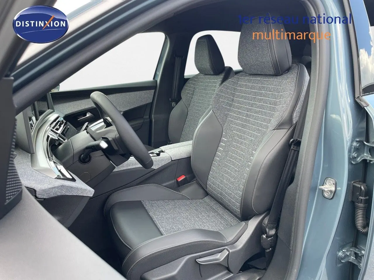 Vue intérieure côté conducteur du Peugeot 3008 Hybrid 2025 en bleu Ingaro Metal, sièges tissu et cuir noir avec surpiqûres contrastées.