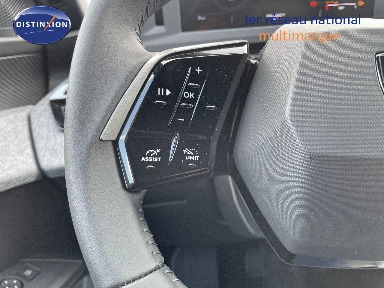 Gros plan sur les commandes au volant à gauche du Peugeot 3008 Hybrid bleu Ingara Metal, avec boutons d'assistance et limitation.
