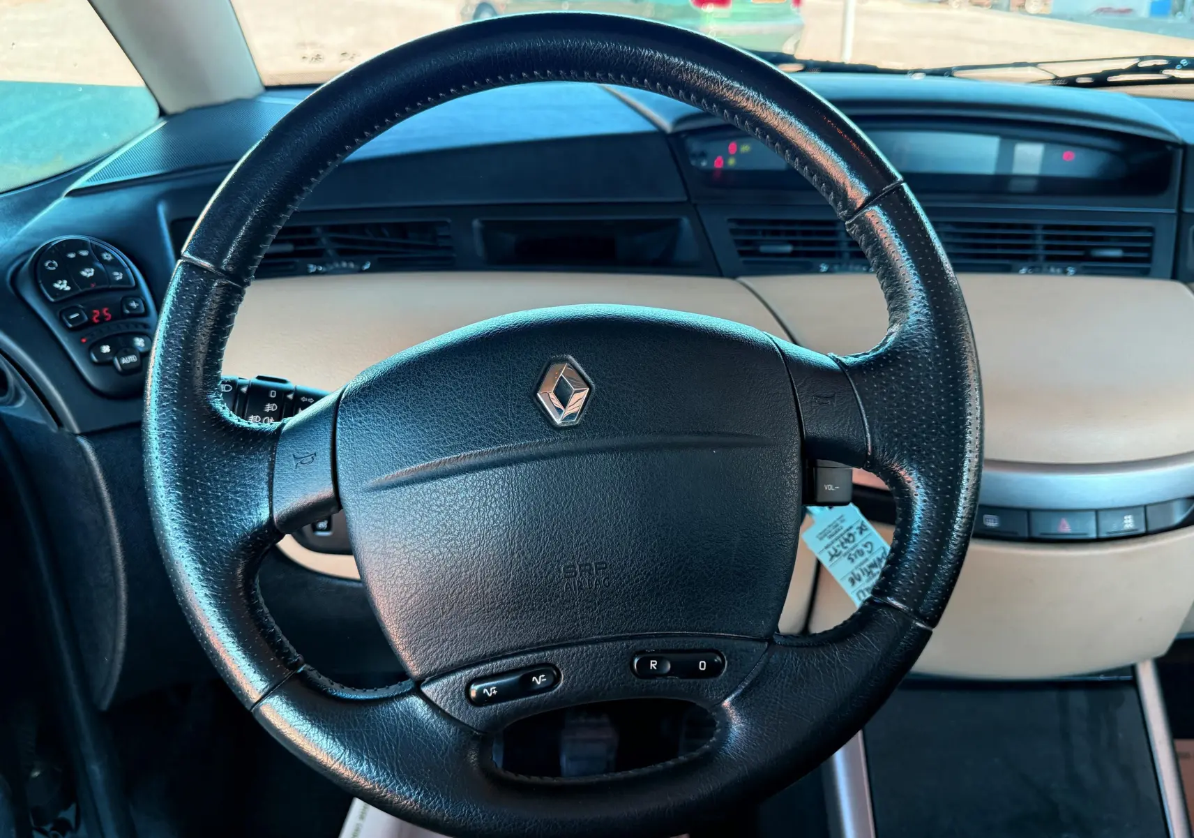 Volant en cuir noir de la Renault Avantime 3.0 V6 de 2002 avec tableau de bord beige et commandes intégrées.
