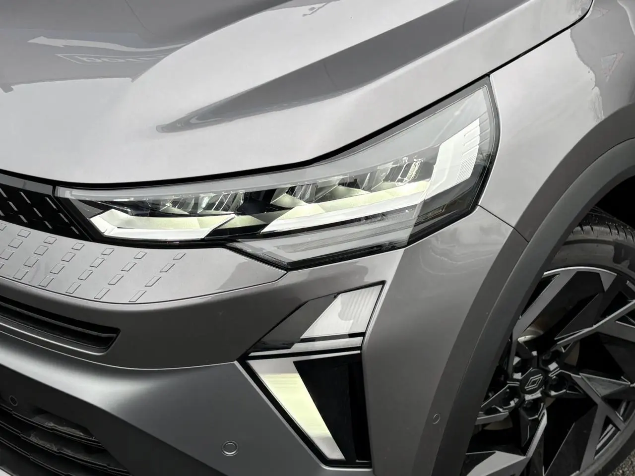 Gros plan sur l'avant droit du Renault Captur gris Cassiopée avec phares LED et jante aluminium 19 pouces noire.