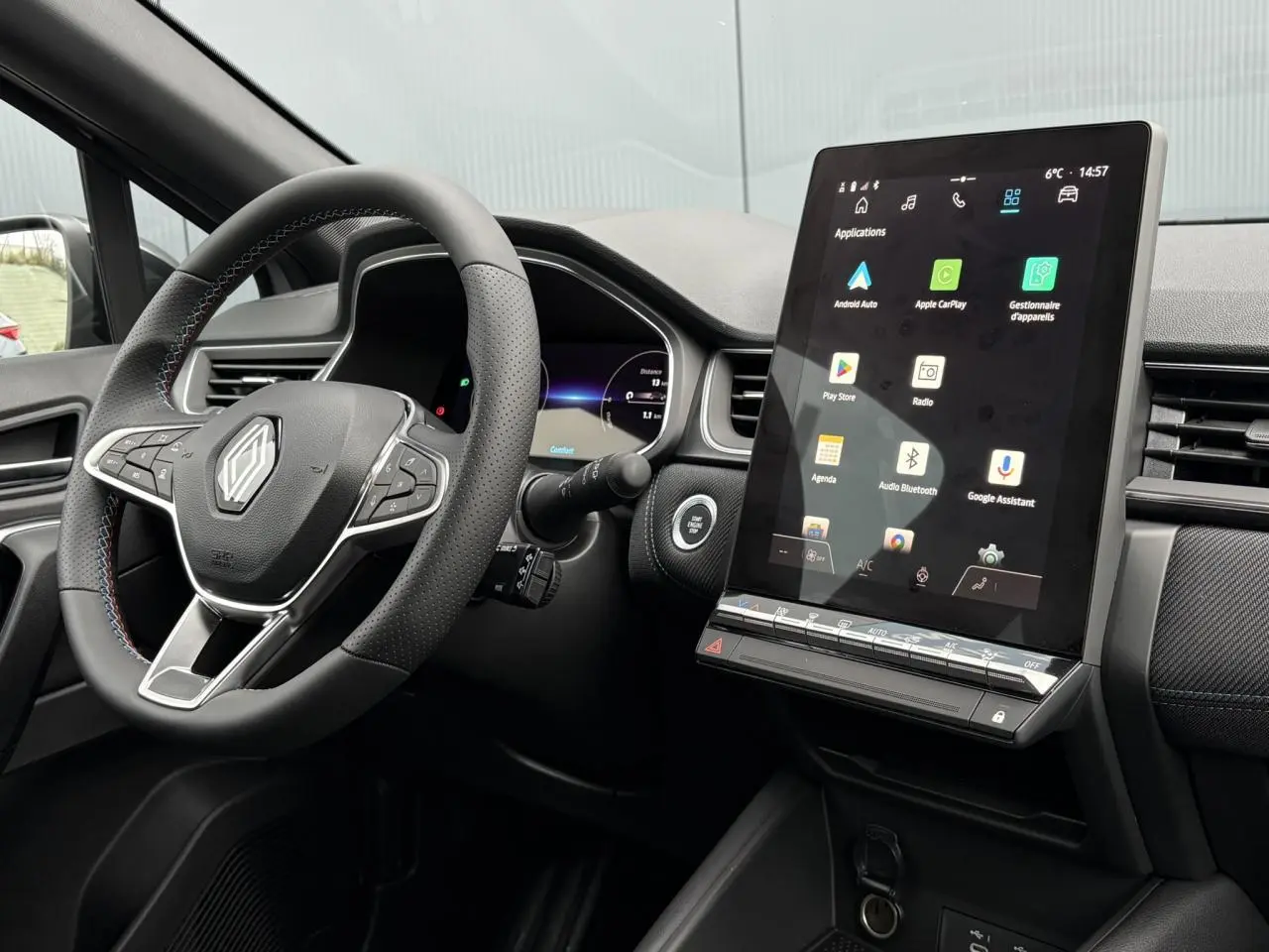 Vue intérieure côté conducteur du Renault Captur 2025, volant avec logo Alpine et écran tactile vertical du système multimédia.