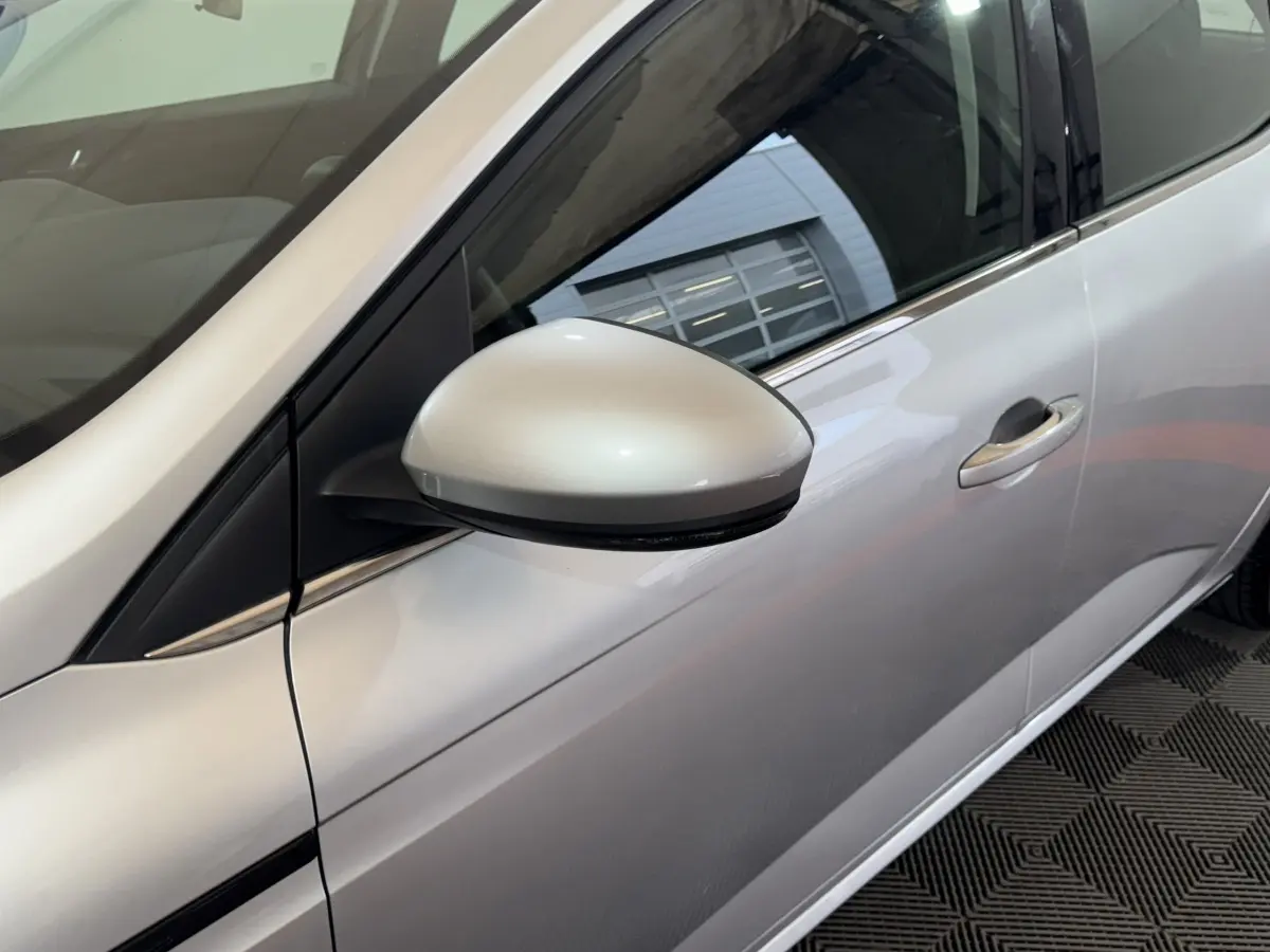 Vue rapprochée du rétroviseur côté gauche d’une Renault Mégane Business gris clair, avec poignée de porte visible.