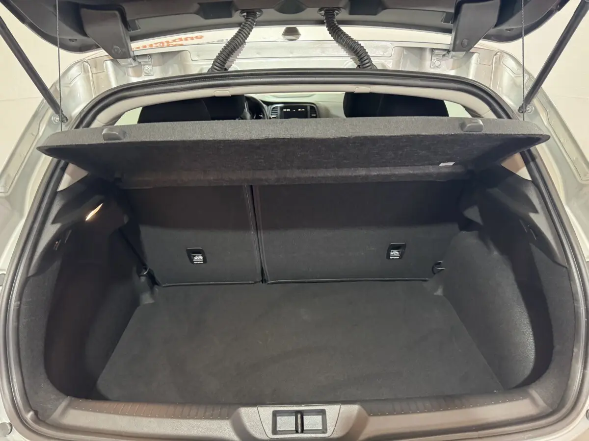 Coffre ouvert de Renault Mégane gris clair, vue arrière montrant l’espace de chargement et la tablette cache-bagages.