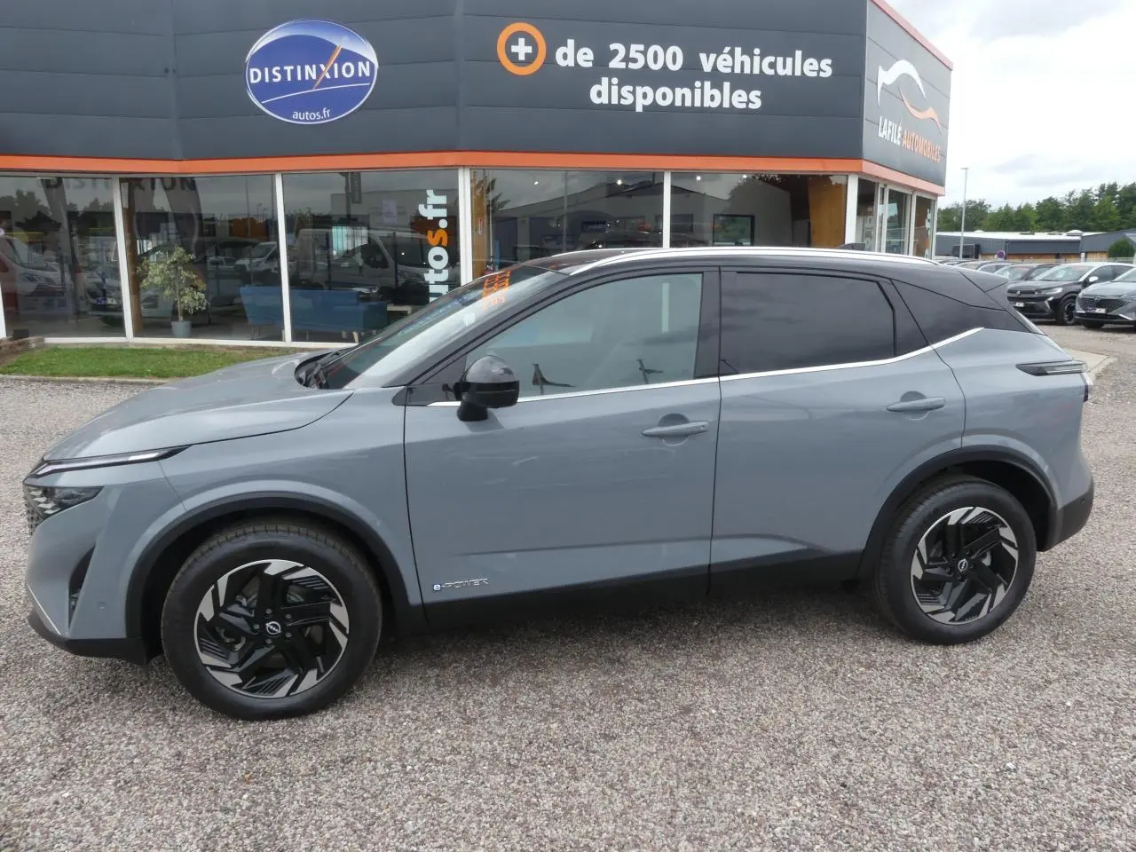 Vue latérale gauche du Nissan Qashqai 1.5 e-Power gris métallisé avec toit noir et jantes alliage noires.