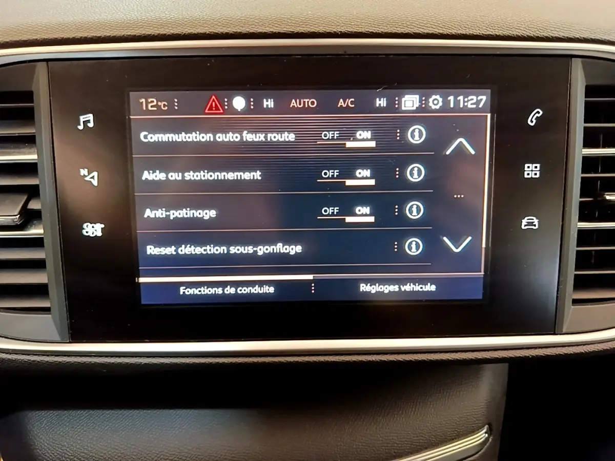 Écran tactile central affichant les réglages d’aide à la conduite dans l’habitacle d’une Peugeot 308 blanche.