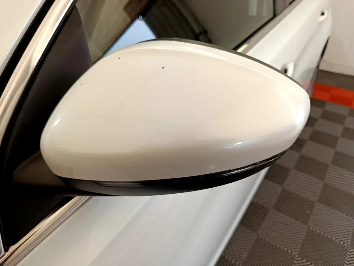 Rétroviseur droit blanc de Peugeot 308 2017 vue rapprochée avec clignotant intégré, sur fond intérieur garage.