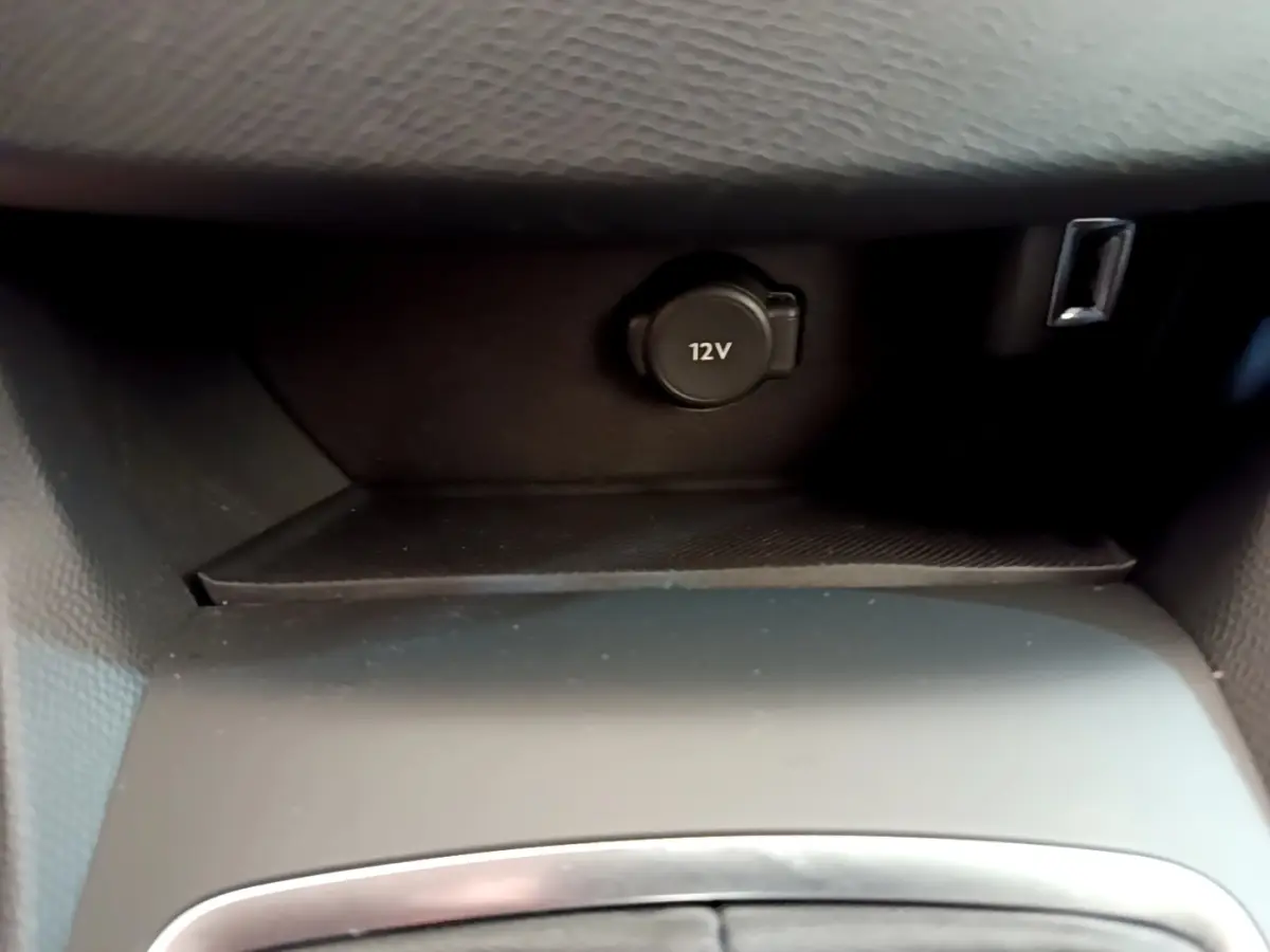 Prise 12V et port USB dans la console centrale d'une Peugeot 308 blanche, vue intérieure rapprochée.