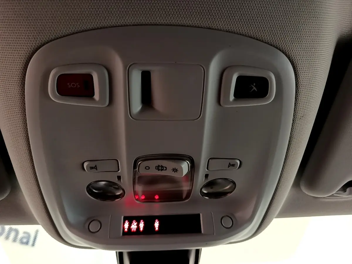 Vue en gros plan du plafonnier intérieur gris avec boutons SOS et éclairage de la Peugeot 308 blanche de 2017.