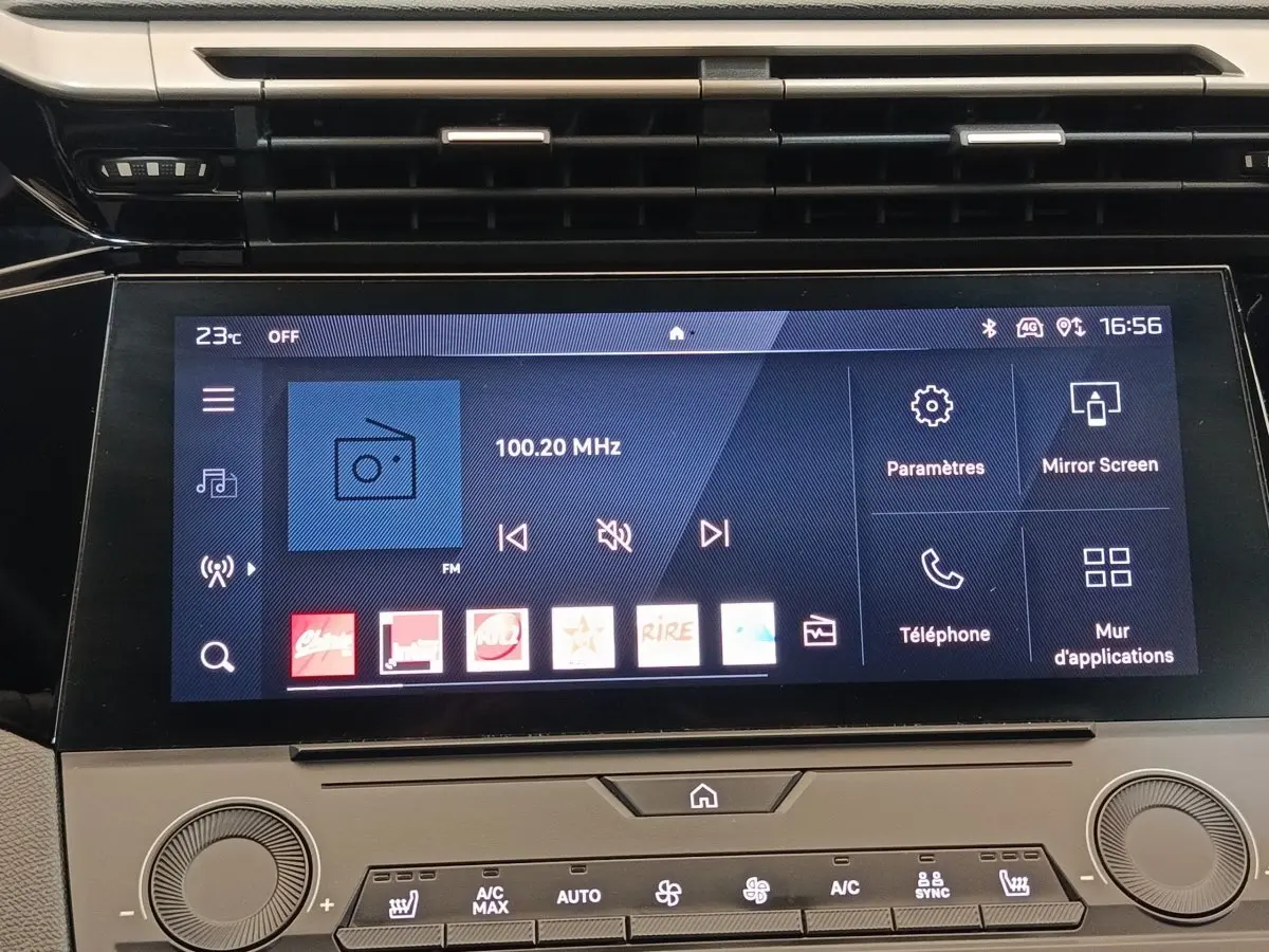 Écran tactile central de la Peugeot 308 vert 2023 affichant la radio FM et les options multimédias.