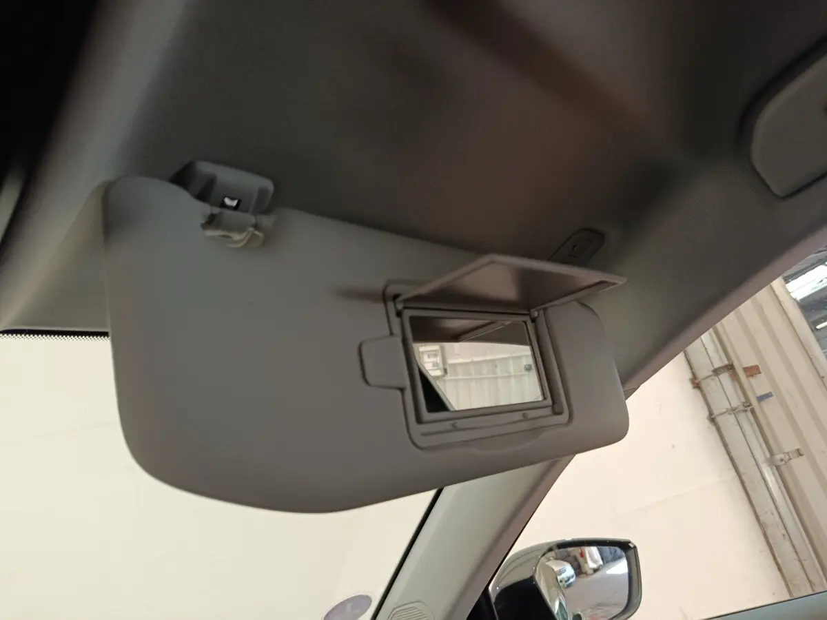 Vue intérieure du pare-soleil côté conducteur avec miroir ouvert sur Peugeot 308 vert, reflet du rétroviseur extérieur visible.