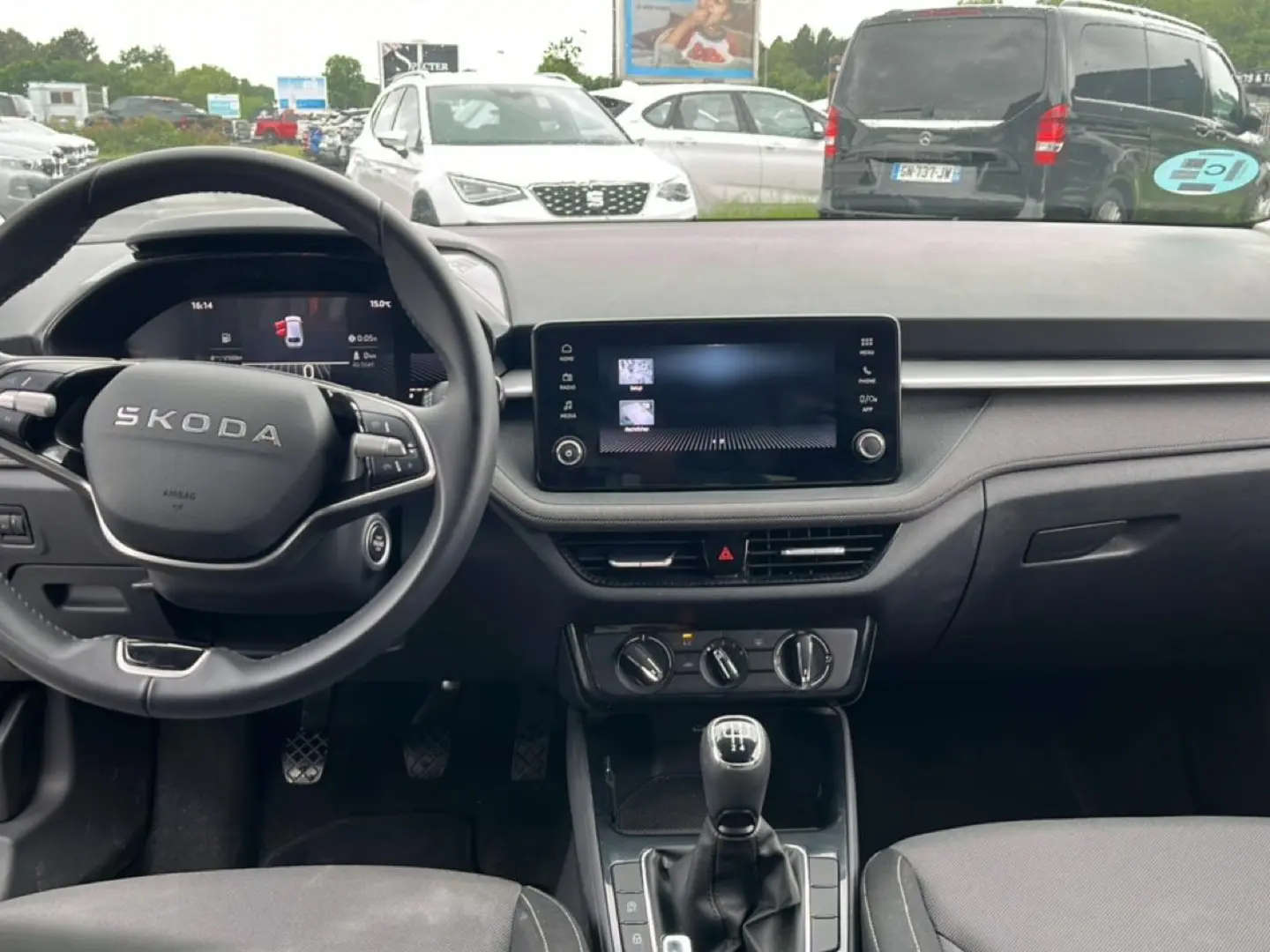 Vue intérieure frontale du tableau de bord et volant cuir noir de la Skoda Fabia 2025 avec écran tactile et boîte manuelle.