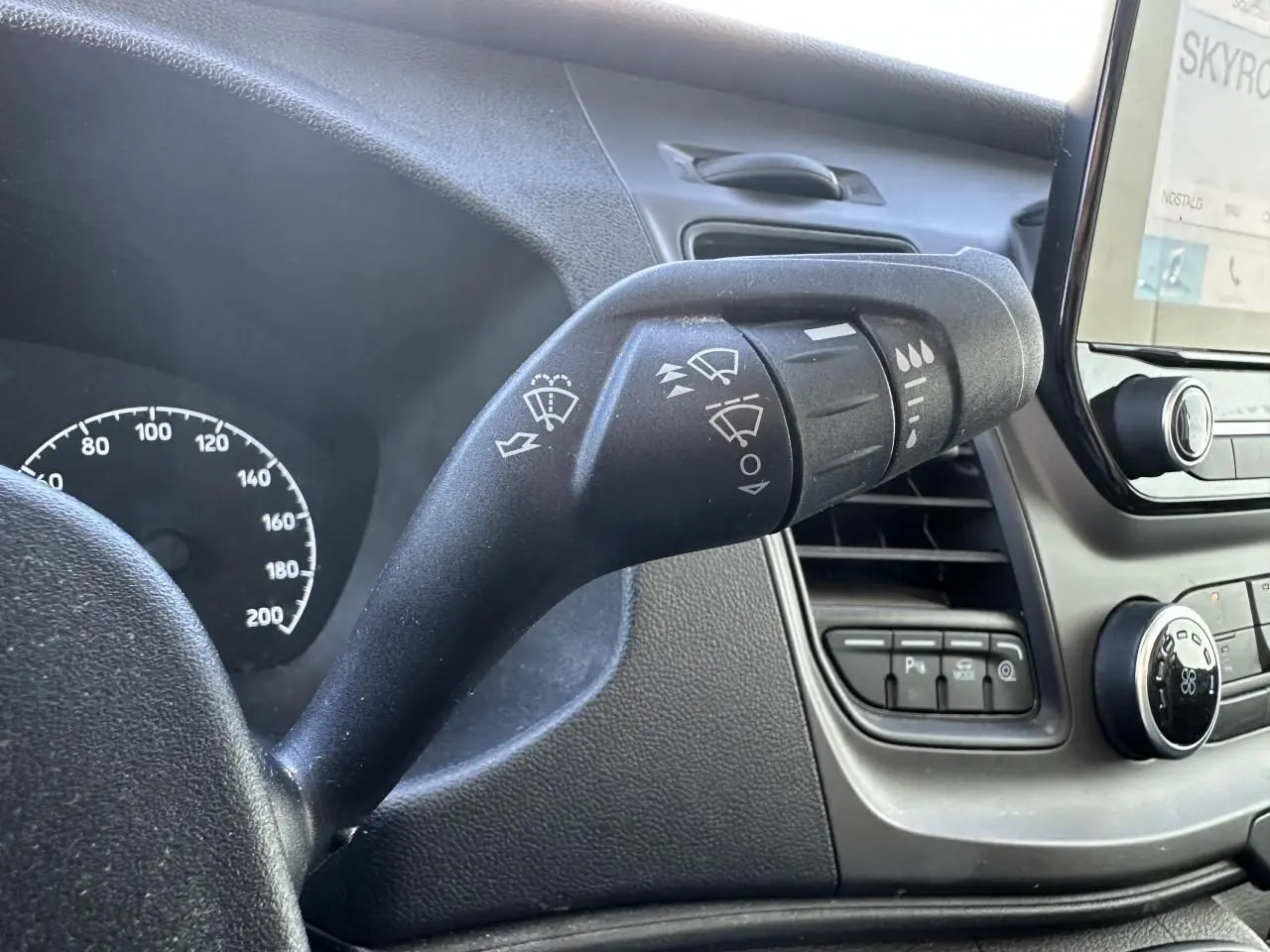 Gros plan sur la commande d'essuie-glace du tableau de bord noir du Ford Transit Fourgon blanc, version 2020.