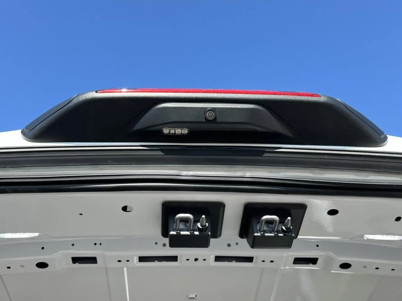 Gros plan sur l'intérieur de la porte arrière blanche du Ford Transit Fourgon, montrant la caméra de recul et les fixations.