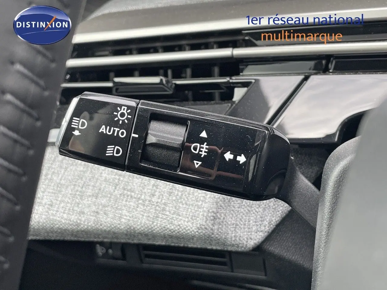 Gros plan sur la commande des feux et clignotants du Peugeot 3008 noir perle métal, intérieur tissu gris.