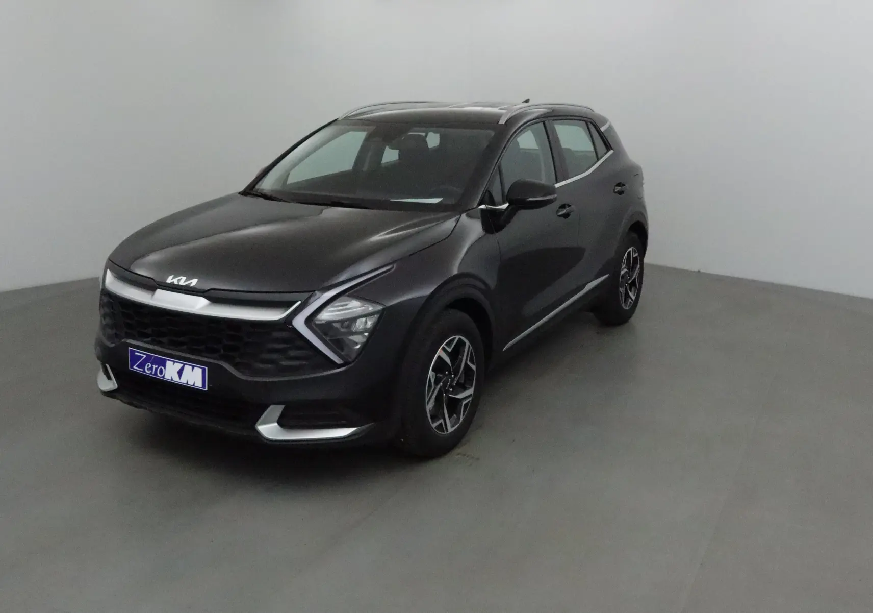 KIA SPORTAGE noir 2025 en 3/4 avant droit, avec calandre distinctive et jantes alliage bicolores.