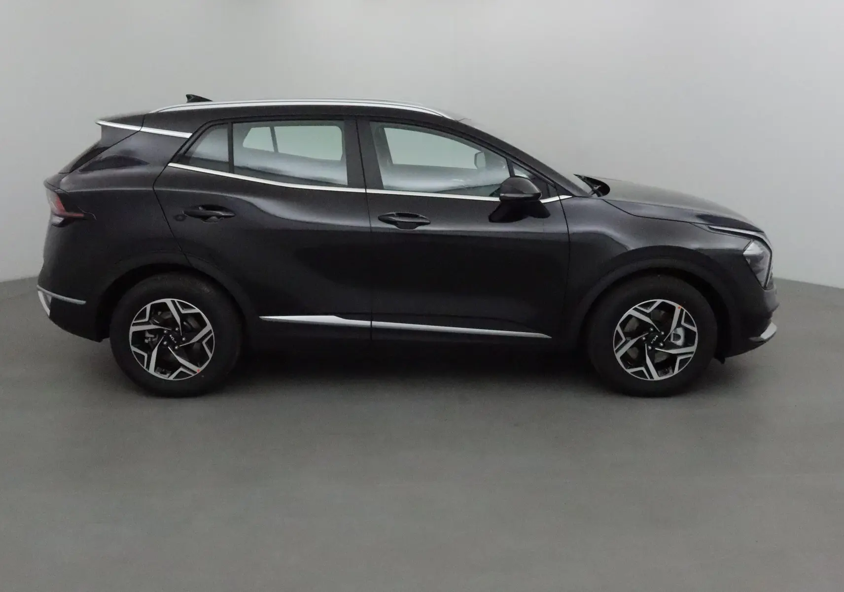 Profil côté gauche du SUV Kia Sportage noir 2025 avec jantes alliage et lignes chromées élégantes.
