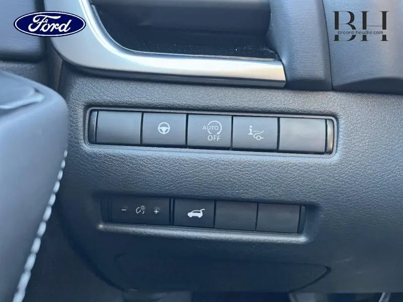 Gros plan sur les commandes noires du tableau de bord du Nissan Qashqai gris Argile, côté gauche du conducteur.