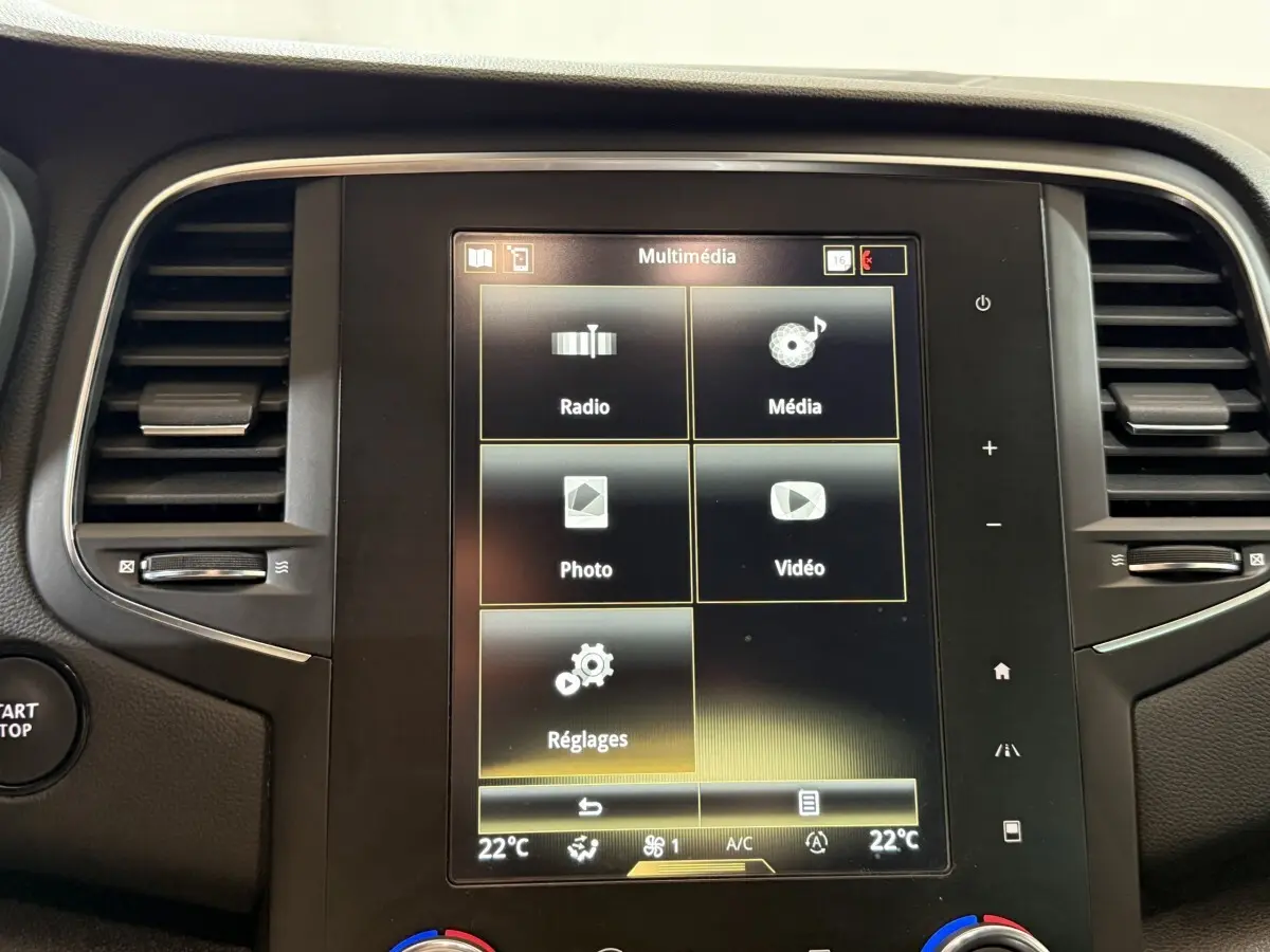 Écran tactile central multimédia de la Renault Mégane Intens gris foncé, avec commandes climatisation et ventilation visibles.