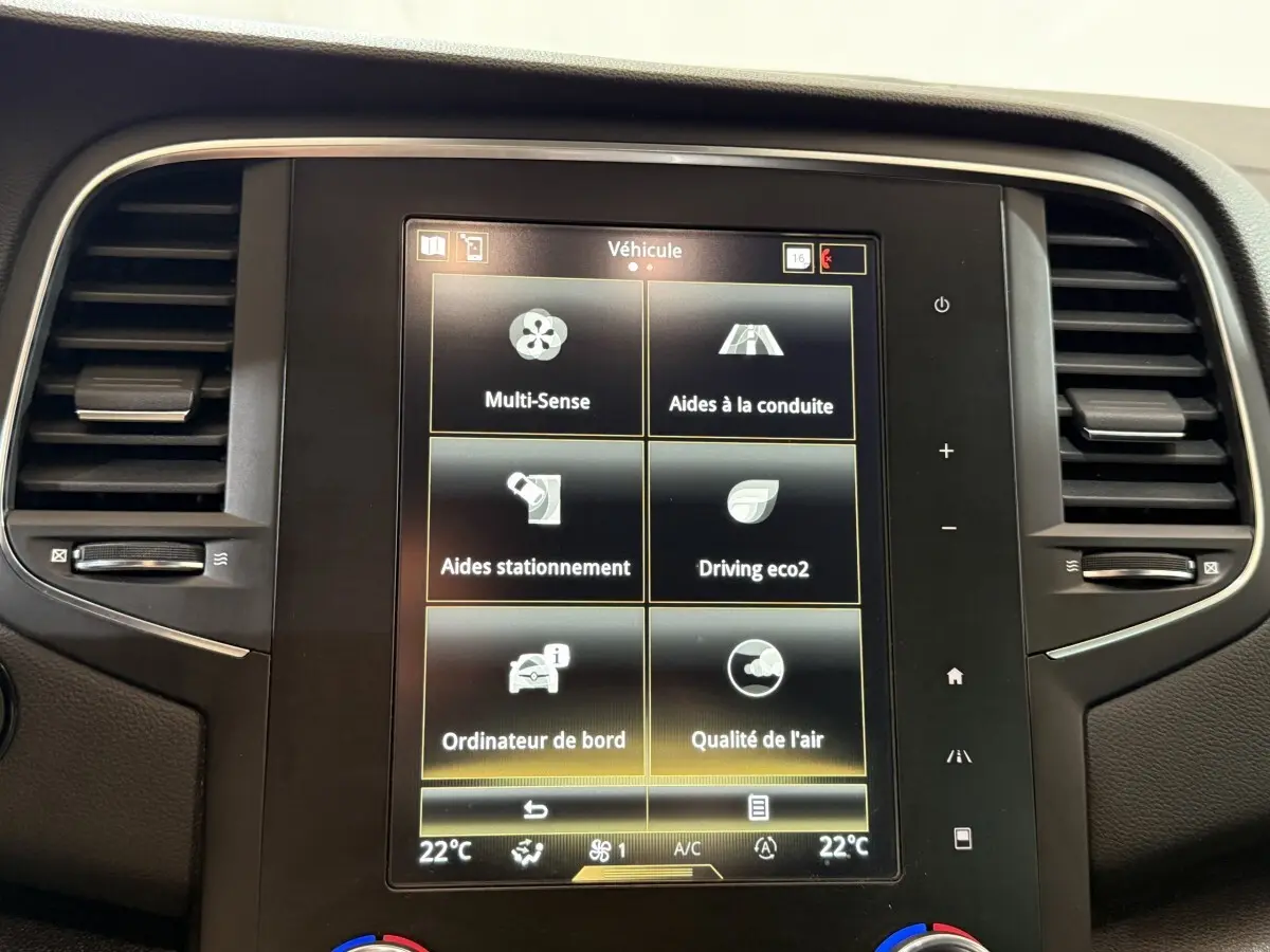 Écran tactile central de la Renault Mégane Intens gris foncé, affichant les options d’aides à la conduite et confort.