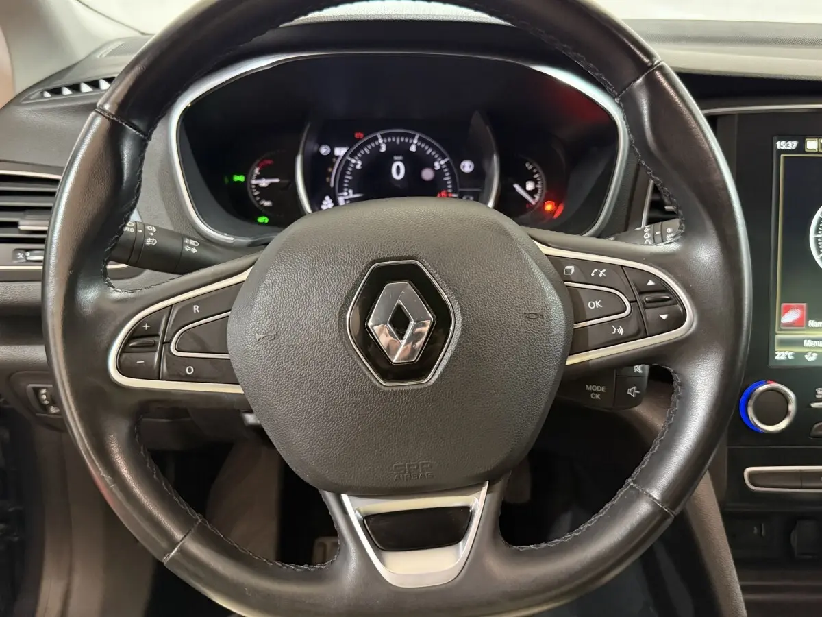 Vue rapprochée du volant cuir noir de la Renault Mégane 2019 avec commandes multifonctions et tableau de bord numérique.