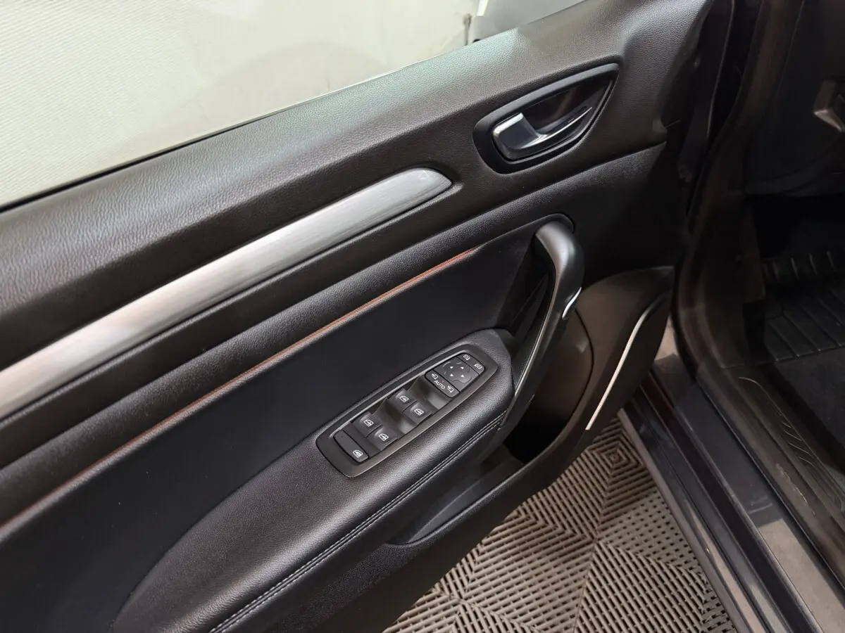 Vue rapprochée de la porte avant gauche noire de la Renault Mégane Intens 2019 avec commandes des vitres et rétroviseurs.