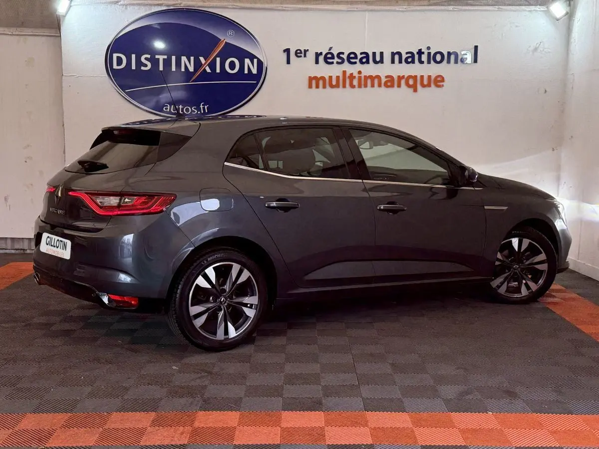 Renault Mégane Intens gris foncé vue de profil côté droit en intérieur avec jantes alliage et feux arrière LED.