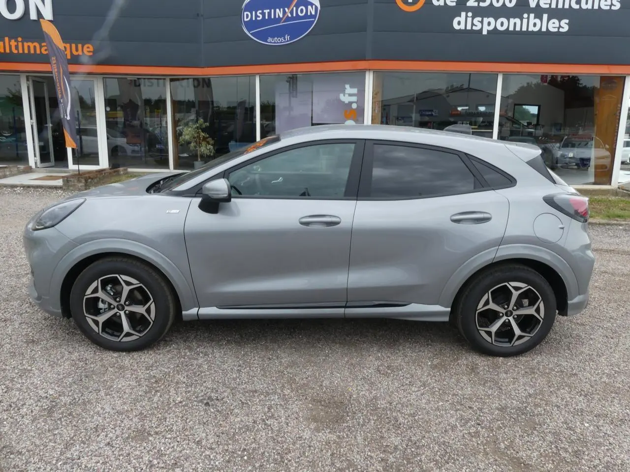 Ford Puma 2025 gris métallisé vu de profil côté gauche, avec jantes alliage 17 pouces et vitres arrière surteintées.