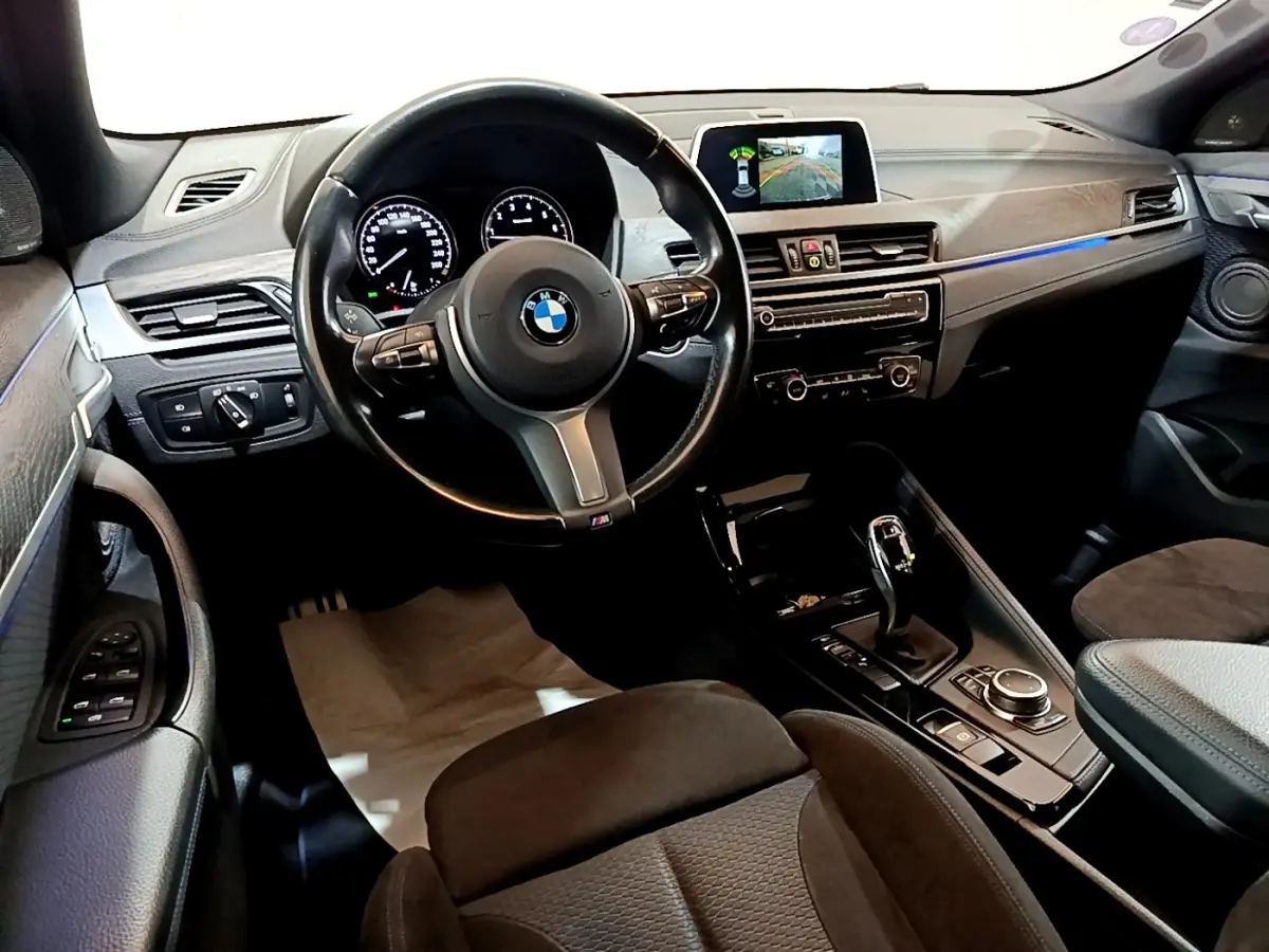 Vue intérieure côté conducteur du BMW X2 sDrive20i M Sport 2019, montrant le volant cuir, tableau de bord et écran tactile.