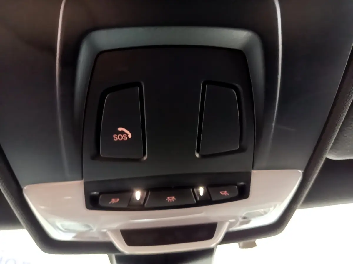 Vue en gros plan du plafonnier noir avec bouton SOS éclairé dans l'habitacle d'une BMW X2 bleu 2019.