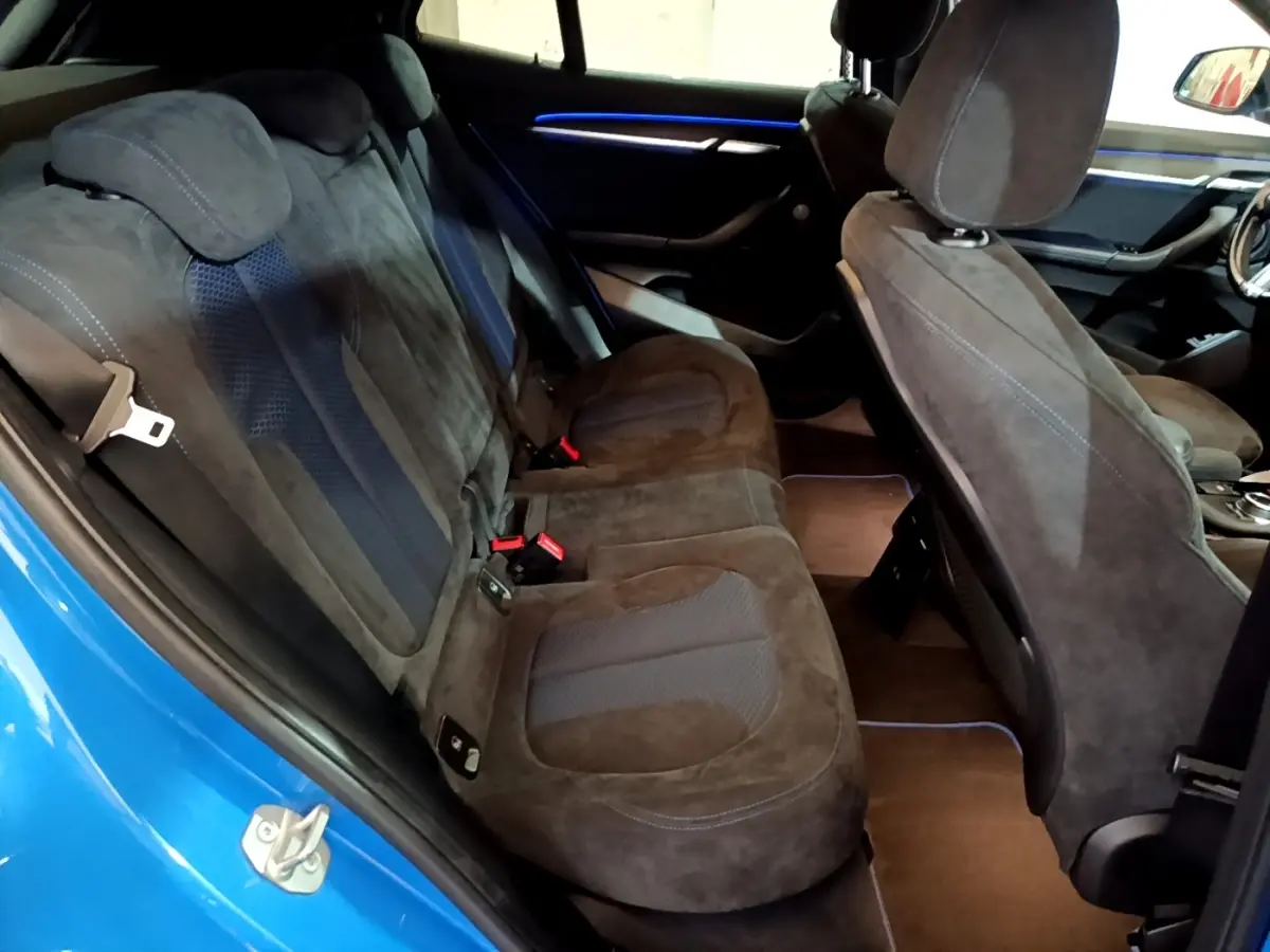 Vue intérieure côté gauche sur la banquette arrière en tissu noir et bleu du BMW X2 sDrive20i M Sport bleu 2019.