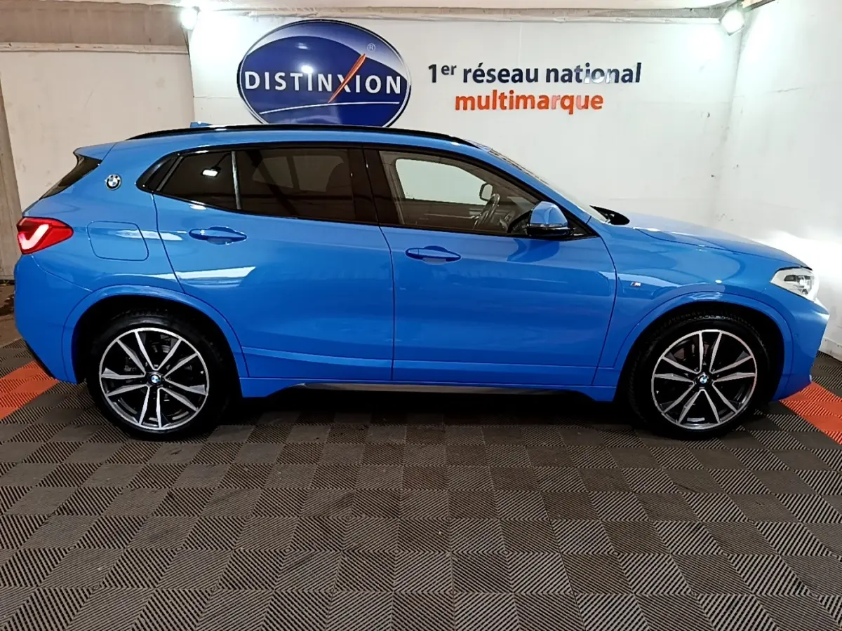 Vue latérale droite d'un BMW X2 bleu 2019 sDrive20i M Sport avec jantes alliage et vitres teintées.