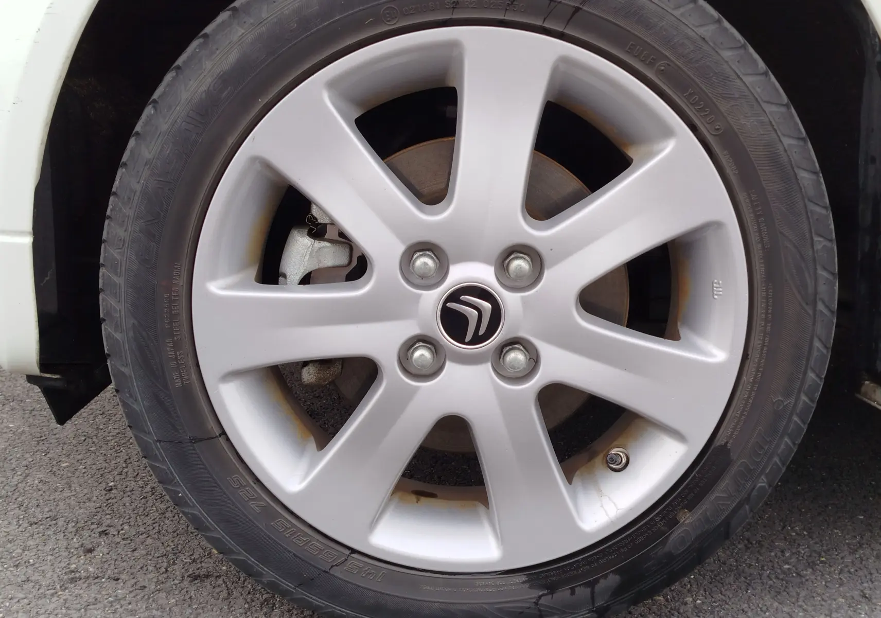 Gros plan sur la jante alliage argentée avec logo Citroën d'une roue avant droite d'une Citroën C-ZERO blanc Antarctique.