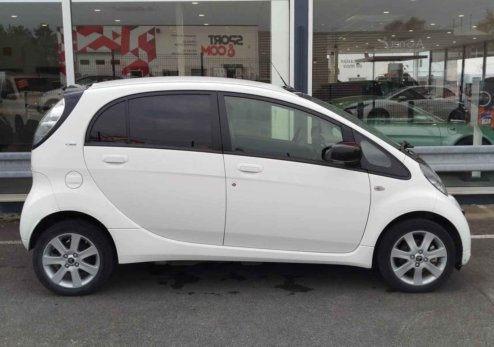 Profil droit d'une Citroën C-ZERO Confort blanche Antarctique, compacte avec vitres teintées et jantes alliage 15 pouces.