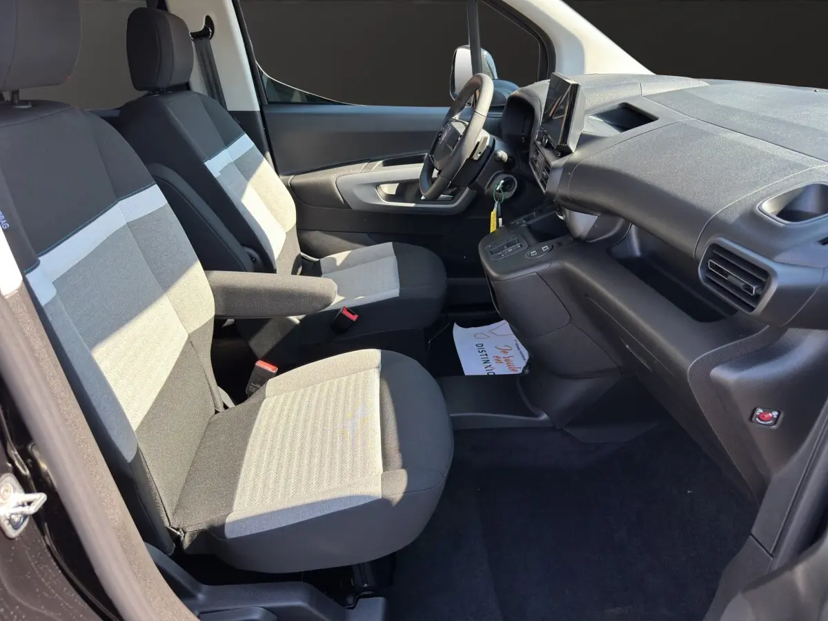 Vue intérieure côté conducteur du Citroën Berlingo noir 2026, montrant sièges tissu bicolore et tableau de bord moderne.