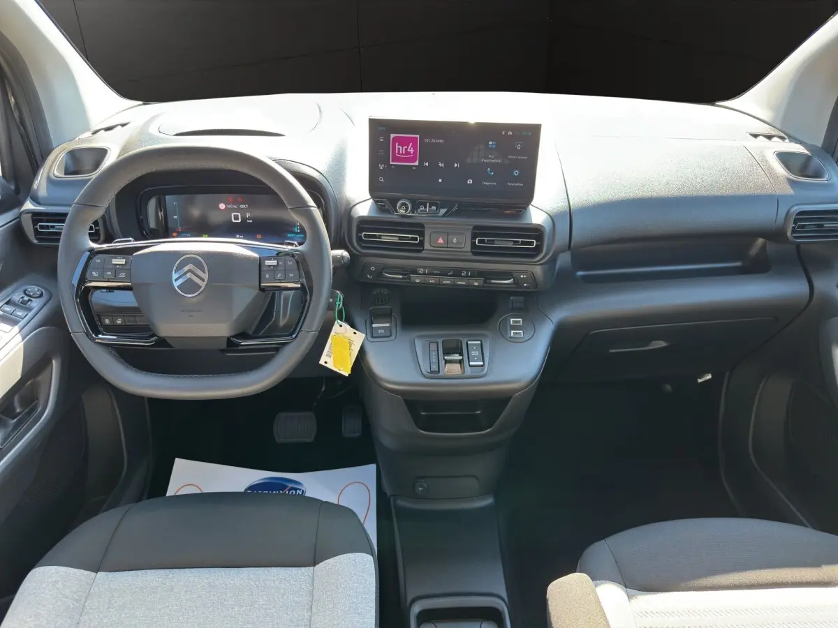 Vue intérieure avant du tableau de bord noir du Citroën Berlingo 2026 avec écran tactile central et volant multifonctions.