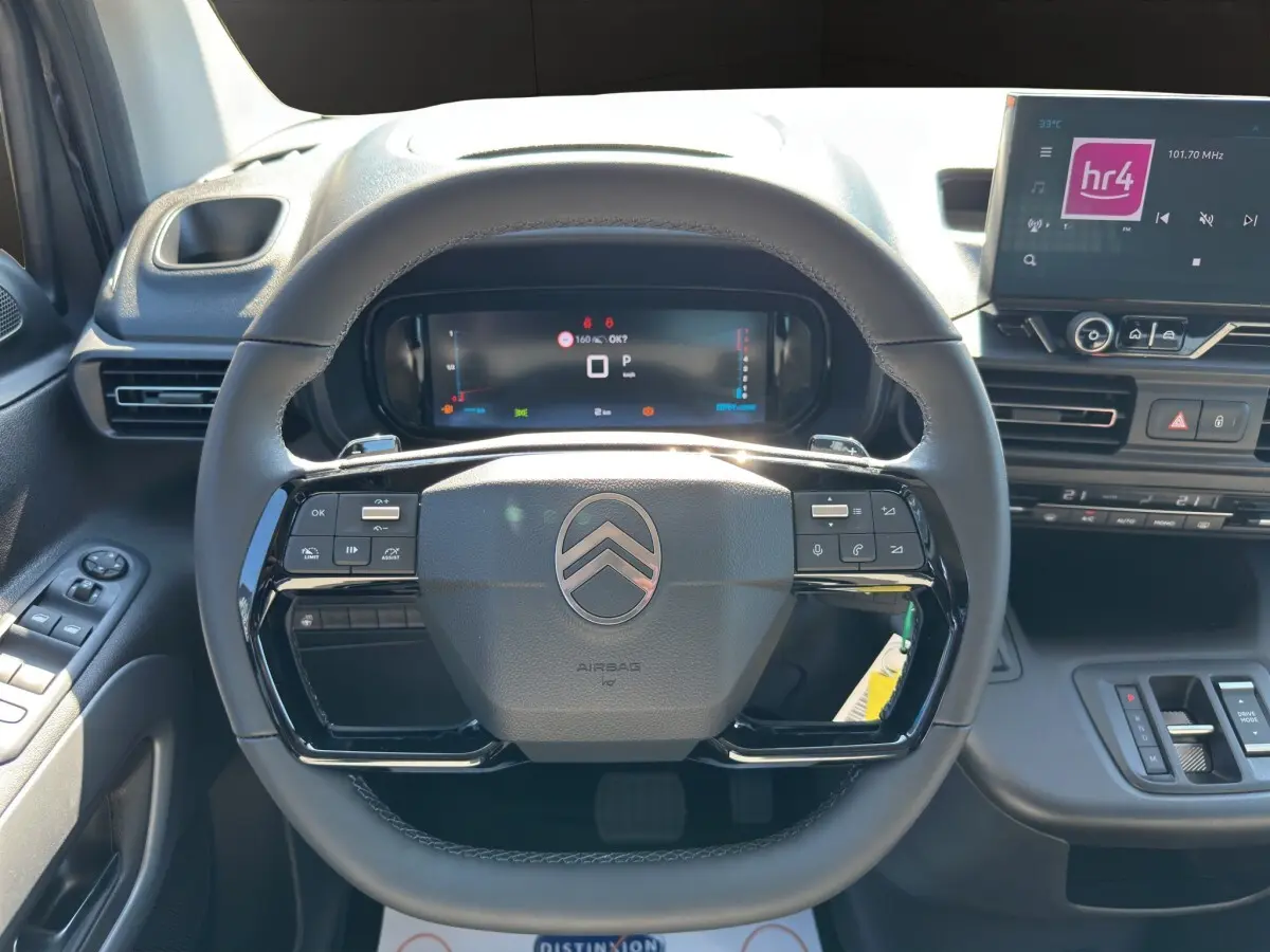 Vue intérieure centrée sur le volant cuir noir multifonctions du Citroën Berlingo 2026 avec tableau de bord digital.